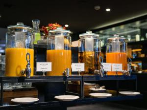 a bunch of jars of orange juice on a shelf at Mercure Budapest Korona in Budapest
