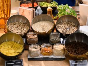 a table with four pans of different types of food at Mercure Budapest Korona in Budapest +107 photos