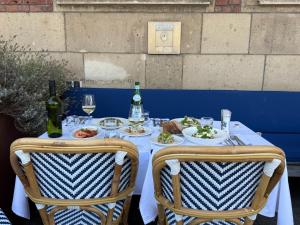 een tafel met borden vol eten en flessen wijn bij Hotel Bleecker by BHC in Bloemendaal