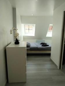 Un dormitorio con una cama y una mesa con flores. en Duplex chic et pratique, en Nogent-sur-Seine