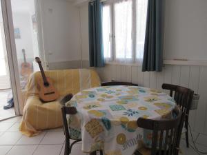 a living room with a table and a guitar at La Bastide in Sanary-sur-Mer