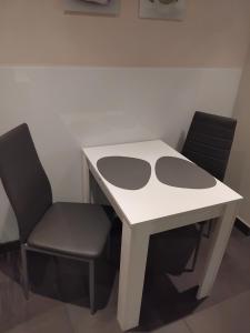 una mesa blanca y 2 sillas en una habitación en Tango apartment, en Breitenworbis