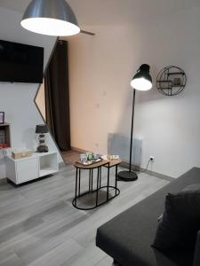Sala de estar con 2 luces y mesa en Duplex chic et pratique, en Nogent-sur-Seine