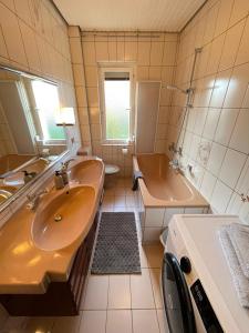 a bathroom with a sink and a tub and a sink at HarzRoots mit Garage in Bad Harzburg