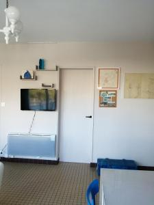 ein Zimmer mit einer weißen Tür, einem Fenster und einem Fernseher in der Unterkunft Terrasse du 7 in Notre-Dame-de-Monts