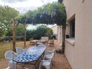 a patio with a blue and white table and chairs at Vacances chez Cali - Maison 10 pers in La Séguinière