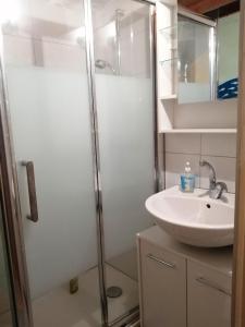 a bathroom with a sink and a shower at Vacances chez Cali - Maison 10 pers in La Séguinière +17 photos