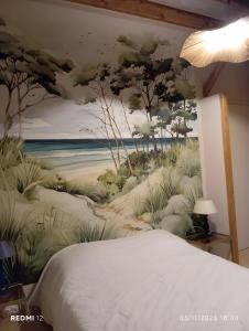 a bedroom with a painting on the wall at Vacances chez Cali - Maison 10 pers in La Séguinière