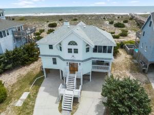 an aerial view of a blue house on the beach at Elegant Updated Oceanfront Home with Pool & Hot Tub in Waves