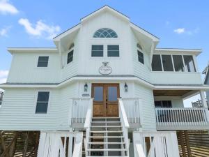 a large white house with a wooden door at Elegant Updated Oceanfront Home with Pool & Hot Tub in Waves +102 photos