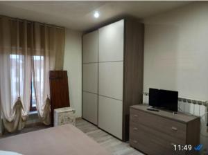 1 dormitorio con cama y vestidor con TV en Centauri, en Cantalupo