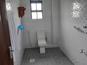 ein kleines Badezimmer mit Toilette und Fenster in der Unterkunft White House II in Naivasha
