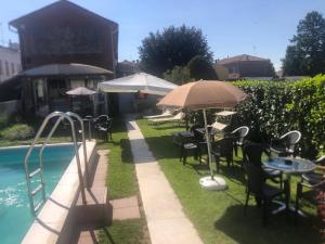 una piscina con mesas, sillas y sombrillas junto a una piscina en Centauri, en Cantalupo