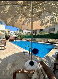 een parasol naast een zwembad bij Turunç Barbaros Apart in Marmaris