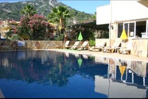 een zwembad met ligstoelen en een gebouw bij Turunç Barbaros Apart in Marmaris