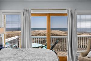 a bedroom with a bed and a view of the ocean at Blue Moon - LUX Oceanfront Pool Hot Tub Theater in Waves