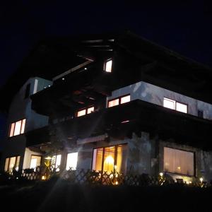 a large building with lit windows at night at Privatzimmer Pendl in Abtenau