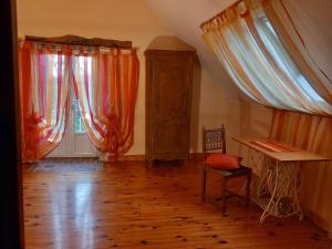 a room with curtains and a table and a chair at Etape à Villeperdue in La Barillonnerie