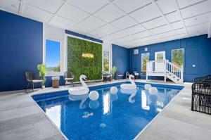 een zwembad met zwanen in het midden van een kamer bij Waterfall & Galaxy Pool & Rooftop Theater Cabin in Pleasant Hill