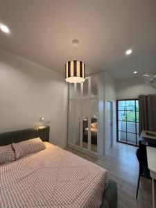 a bedroom with a bed and a chandelier at Minimal Apartment in Central of city Near Central 1 km in Nakhon Pathom