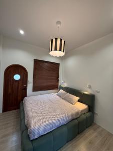 a bed in a bedroom with a green couch at Minimal Apartment in Central of city Near Central 1 km in Nakhon Pathom +12 photos