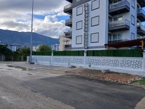 eine weiße Wand mit Graffiti darauf neben einem Gebäude in der Unterkunft ŞAHİNER APART Otel in Finike