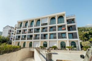 a large white building with windows and a balcony at Beachfront apartment with sea view in Meljine