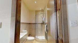 a bathroom with a shower and a toilet and a sink at The Horse & Farrier in Otley