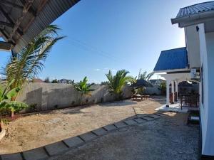 a backyard of a house with a fence at Malaika White House Apartment & Spa in Kiwengwa +2 photos