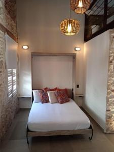 a bedroom with a bed with two pillows and two lights at Duplex Colonial Getsemani in Cartagena de Indias