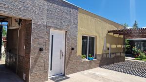 a brick building with a white door and a patio at departamento familiar 2 in Malargüe