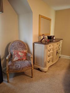 1 dormitorio con tocador, silla y espejo en The Cardinal Room, en Raleigh