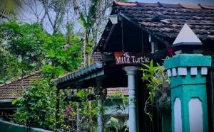 a house with a sign on the side of it at Villa Turtle in Galle