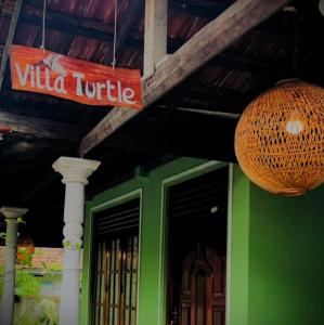 a sign on a building with a green at Villa Turtle in Galle