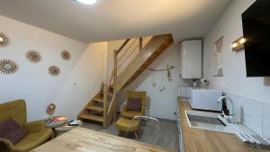 a living room with a kitchen and a stairway at Le petit Cocon in Nevers