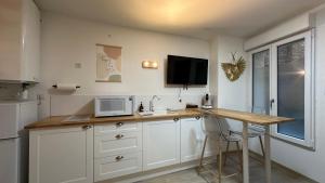 a kitchen with a counter with a microwave and a table at Le petit Cocon in Nevers