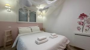a bedroom with a white bed with towels on it at Le petit Cocon in Nevers