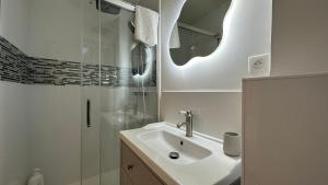 a white bathroom with a sink and a shower at Le petit Cocon in Nevers +8 photos
