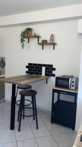 a kitchen with a table and a stool and a counter at Gîte Le Studio 7 in Sully-sur-Loire