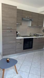 a kitchen with wooden cabinets and a blue table at Gîte Le Studio 7 in Sully-sur-Loire
