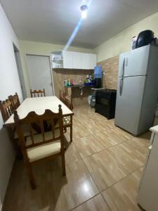 a kitchen with a table and a white refrigerator at Apartamento em condomínio, alugo para o ENCANTOS DO NATAL GARANHUNS in Garanhuns