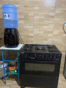 a black stove with a plastic jug on top of it at Apartamento em condomínio, alugo para o ENCANTOS DO NATAL GARANHUNS in Garanhuns +10 photos