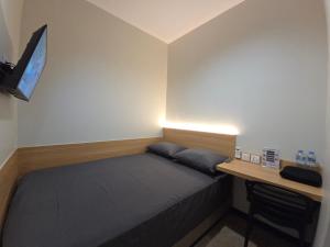 a small bedroom with a bed and a desk at Hello Inn permata hijau in Stasiun Tawang