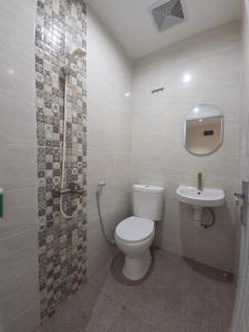 a bathroom with a toilet and a sink at Hello Inn permata hijau in Stasiun Tawang
