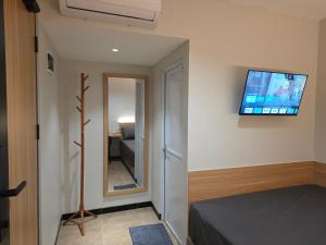 a bedroom with a bed and a television on the wall at Hello Inn permata hijau in Stasiun Tawang +10 photos