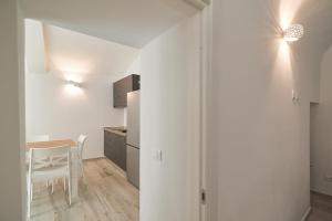 a small kitchen and dining room with white walls and a table at AM8 - Cozy apartment in the center in Perugia +15 photos