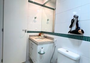 a small bathroom with a sink and a toilet at RefugioBacutia- Prédio FRENTE MAR Bacutia- 6 pessoas- 3 Quartos com AR sendo 1 suite - varanda- sala de estar e jantar Ampla -Piscina e Sauna no Prédio in Guarapari