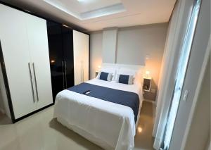 a bedroom with a large white bed and a window at RefugioBacutia- Prédio FRENTE MAR Bacutia- 6 pessoas- 3 Quartos com AR sendo 1 suite - varanda- sala de estar e jantar Ampla -Piscina e Sauna no Prédio in Guarapari +51 photos