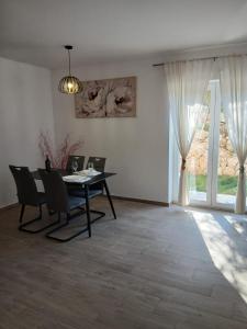 a dining room with a table and chairs and a window at Apartman Lasko in Razvala
