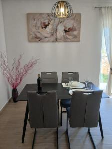 a dining room with a black table and chairs at Apartman Lasko in Razvala